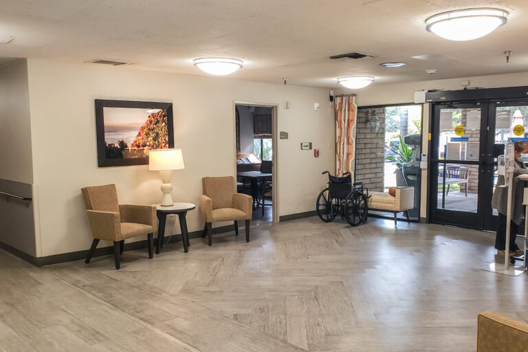 A room with chairs, tables and a wheel chair.
