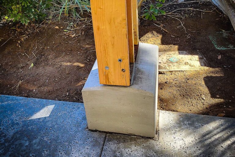 A wooden post on top of concrete block.
