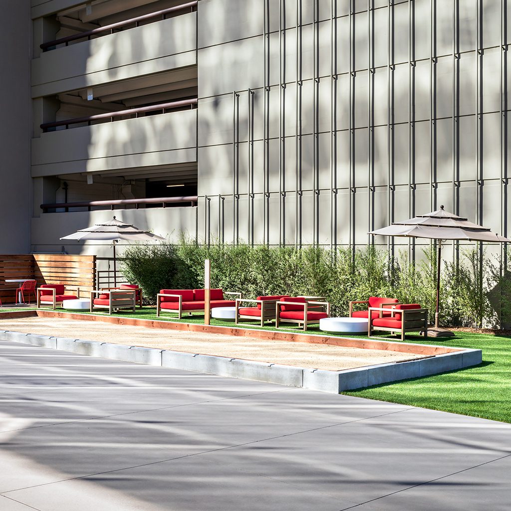 Outdoor patio with red chairs and umbrellas.