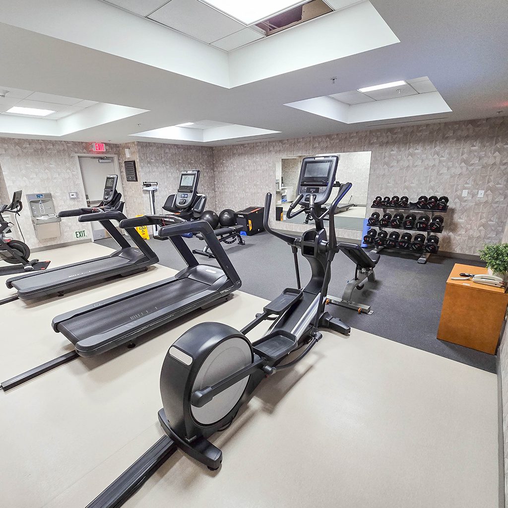 Small gym with treadmills and weights.