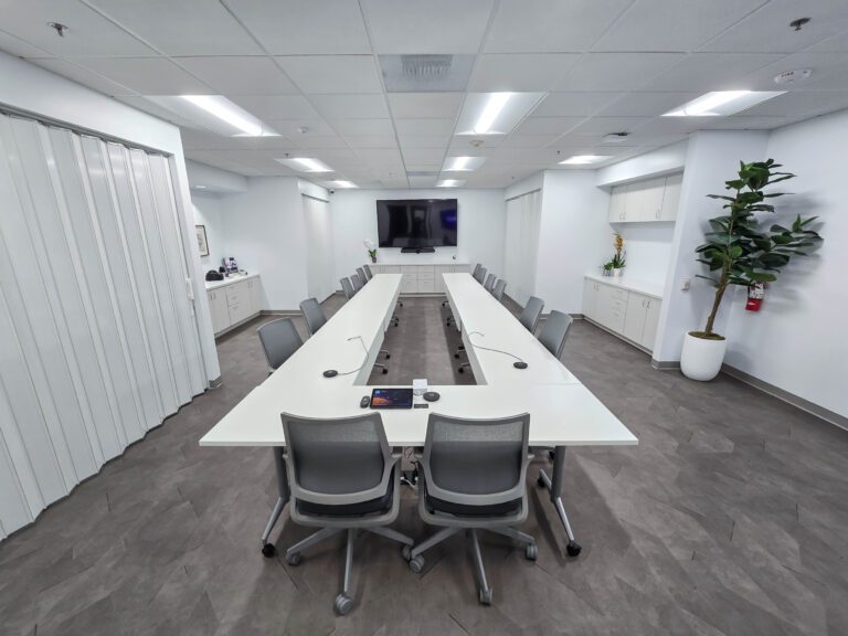 Modern conference room with long white table.