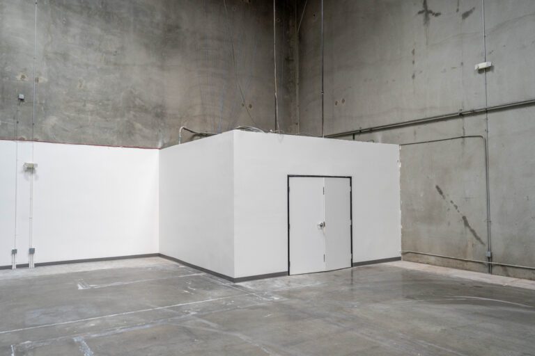 Empty industrial warehouse interior with white office