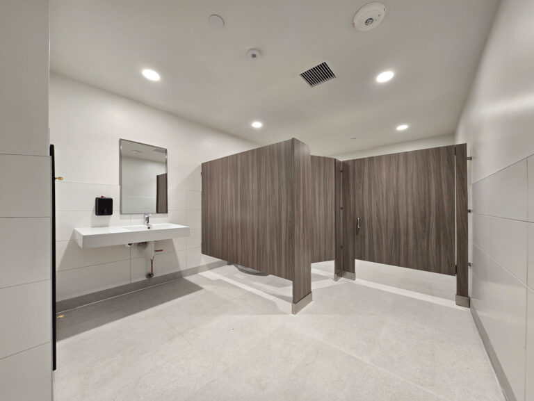 Bright modern restroom with wood-tone stalls